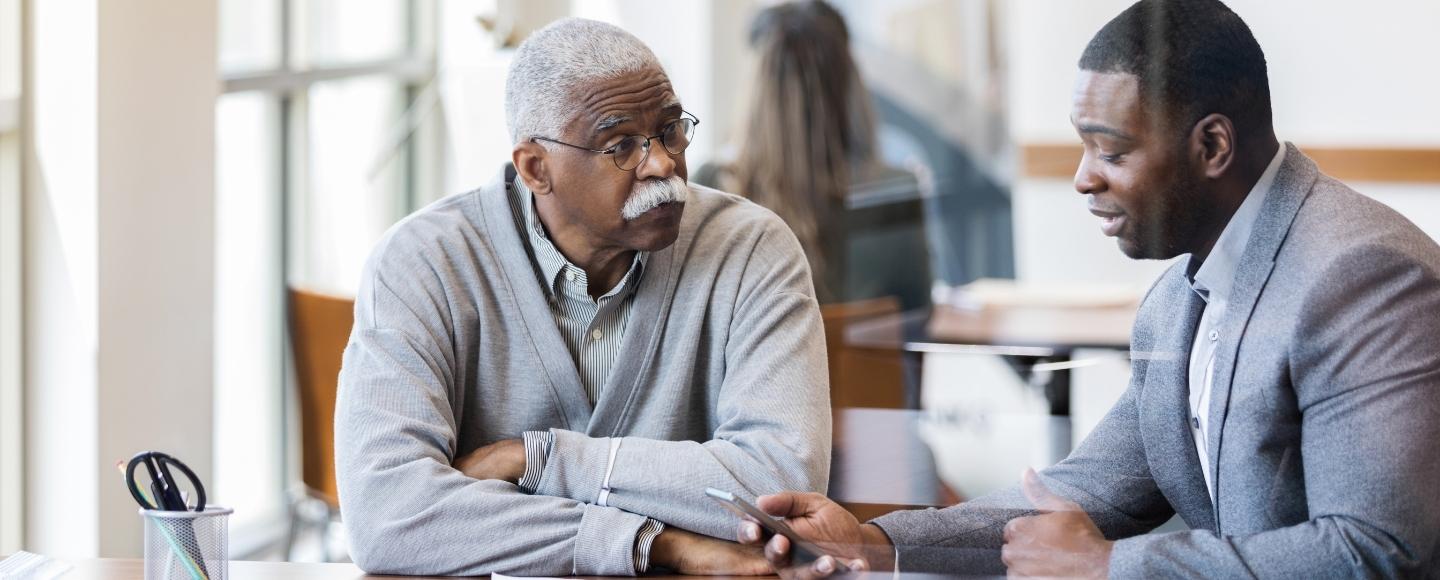 senior man talking with a financial advisor at a bank